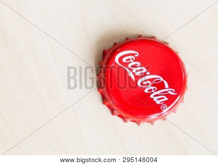 Moscow, Russia - April 4, 2019: Used Crown Cork Bottle Cap From Coca-cola Beverage On Wooden Board W