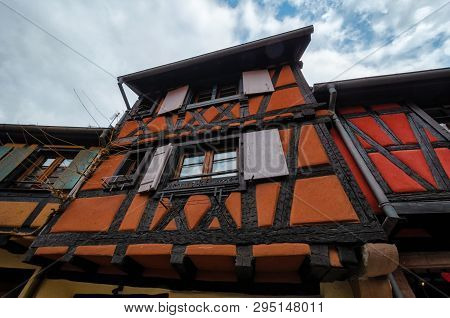 Fragment Of The Facade Of A Half-timbered House. Bottom View. France. Alsace. The Color Of The Walls