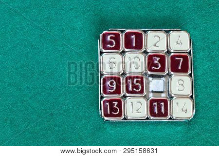 Top View Of 15-puzzle (magic 15) Sliding Puzzle Game On Green Baize Table With Copyspace