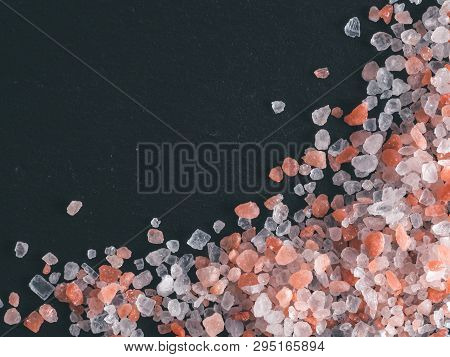 Himalayan Pink Salt In Crystals On Black Stone Background. Copy Space