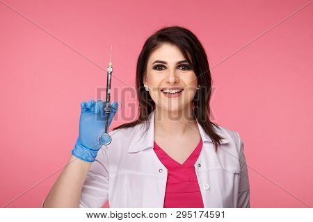 Woman Dentist Posing With Dental Tools Isolated Over The Pink Background.