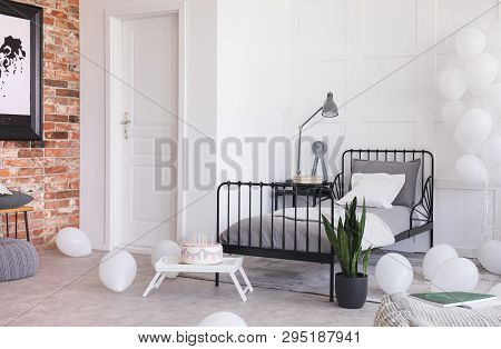 Birthday Celebration In Trendy Industrial Bedroom With Brick Wall And Metal Bed With Grey Bedding