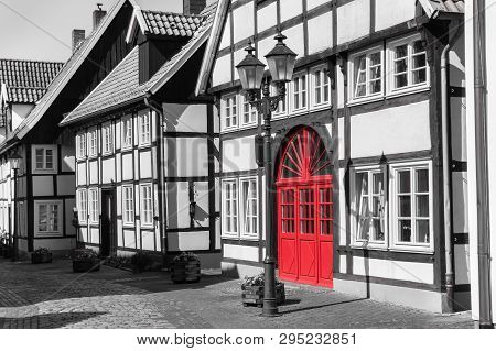 Street With Old Half Timbered Houses In Rheda, Germany, Black And White With Door In Red