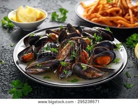 Mussels With White Wine, Garlic, Lemon And Herbs In A Plate, French Fries. Rustick Background. Seafo