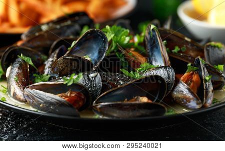 Mussels With White Wine, Garlic, Lemon And Herbs In A Plate, French Fries. Rustick Background. Seafo