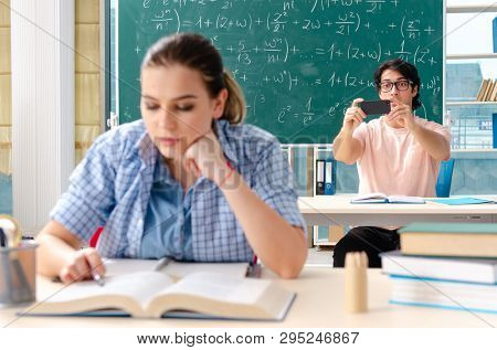 Young students taking the math exam in classroom 