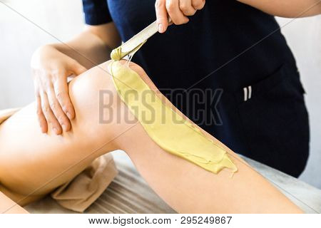 The Beautician Does Waxing Legs With Shugaring