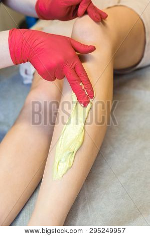 The Beautician Does Waxing Legs With Shugaring