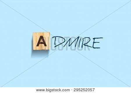 Admire. Words Written On A Wooden Block. Blue Background. Isolated. Business Concept. Admire Concept