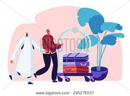 Hotel Stuff Meeting Arabic Guest In Hall Carrying Luggage By Cart. Muslim Businessman Stay In Guesth