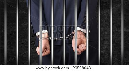 Close convicted man with handcuffs behind grids