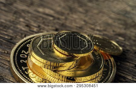 A Few Gold Coins Fineness 999.9 On A Background Of Blurred Wood Texture.