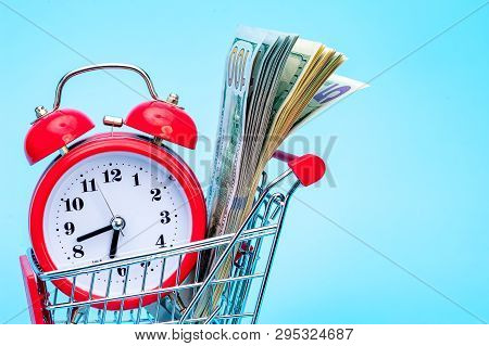 Red Retro Alarm Clock And Dollar Bills In Shopping Cart On Blue Background. Shopping Time, Market, C