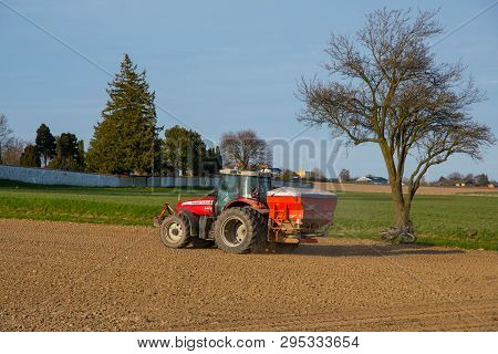 Kalvehave Denmark - April 17. 2018: Farmer On A Massey Ferguson Tractor Spreading Fertilizer