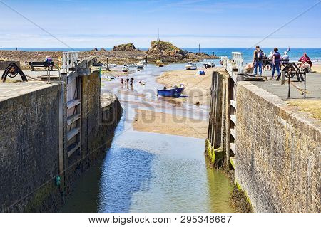 6 July 2018: Bude, Cornwall, Uk - The Canal And Lock Gates Standing Open To The Sea, As People Relax