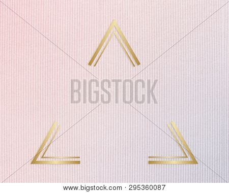 Gold ftriangle rame on a pinkish blue fabric background
