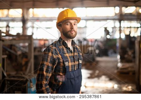 Professional technician or engineer of large heavy industry or machinebuilding plant standing in front of camera