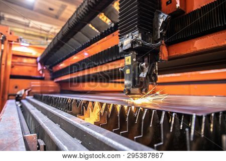 Welding or cutting industrial machine processing iron sheet on serrated substrate in modern machinebuilding plant