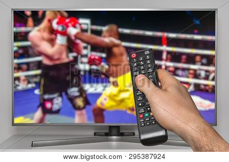 Boxing Match On Tv And Human Hand With Tv Remote Controller