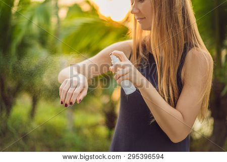 Woman Spraying Insect Repellent On Skin Outdoor