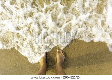 Top View On Naked Feet On Sandy Beach Copy Space - Foaming Sea Texture Background Ocean While Standi