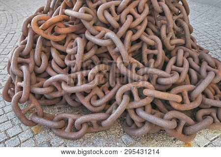 Rusty Anchor Chain Piled Up On The Pier, Close-up