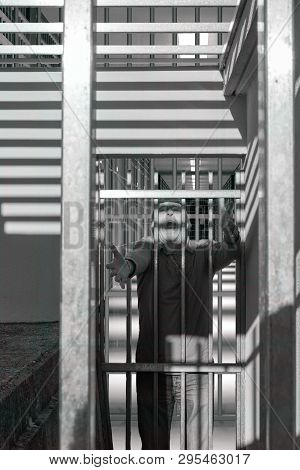 Man Condemned Behind Bars Of A Prison Door, Shouting In Fear And Anger