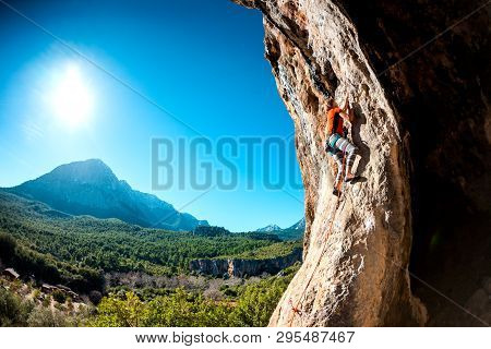 A Woman Trains On A Natural Rocks. The Girl Overcomes The Difficult Climbing Route On The Turkish Ro