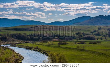 Olt River In Transylvania, Romania, Blue Mountains At Early Spring, Landscape Image.