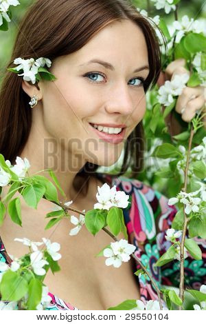 ภาพของสาวสวยหอมดอกไม้สีขาวในสวน