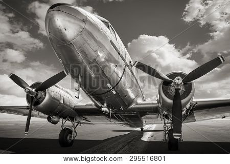 Historical Aircraft On A Runway Against A Cloudy Sky