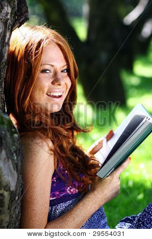 bella ragazza legge il libro nel parco