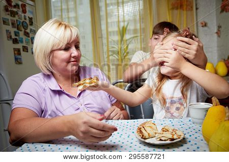 Kirov, Russia - November 04, 2018: Adalt Mother And Her Young Daughter And Son In A Kitchen With Pan