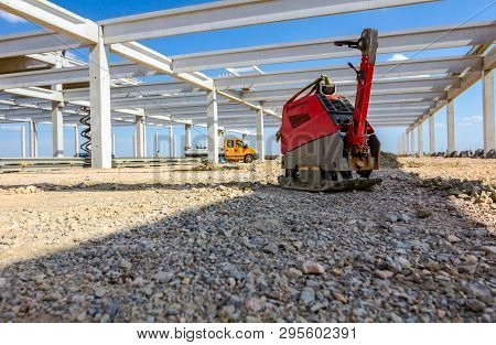 Used Plate Compactor, Vibratory Hammer, Jumping Jack Machine, Power Tool Placed In Shadow At Constru