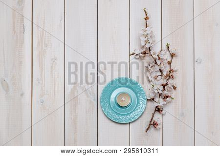 Apricot Branches With Flowers And Candle On A Plate On A Wooden Background