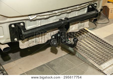 Close-up On A New Black Tow Hitch Installed On A Modern Car With A Beige-colored Bumper Removed In A