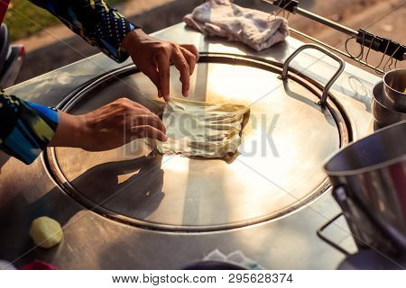 Hands Of Street Vendor Cooking Thai Style Sweet Roti Bread On Steel Roti Pan Or Big Flat Frying Pan.
