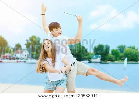 Young Smiling Woman In Light Clothes Is Holding White Racket And Ball In Her Hands. Cheerful Female 