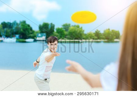 Young Smiling Woman In Light Clothes Is Holding White Racket And Ball In Her Hands. Cheerful Female 