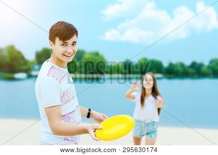 Young Smiling Woman In Light Clothes Is Holding White Racket And Ball In Her Hands. Cheerful Female 
