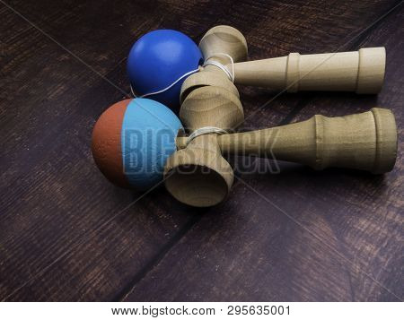 Classic Japanese Game Kendama On Wooden Background. Two Playing Kendamas, New And Used