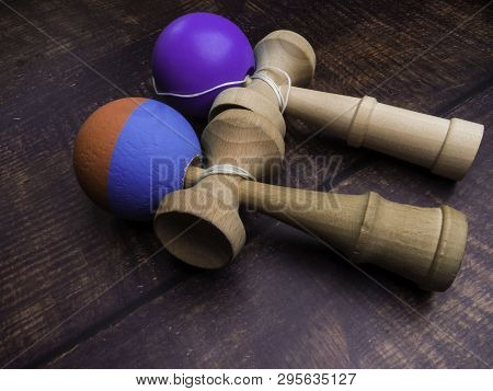 Classic Japanese Game Kendama On Wooden Background. Two Playing Kendamas, New And Used