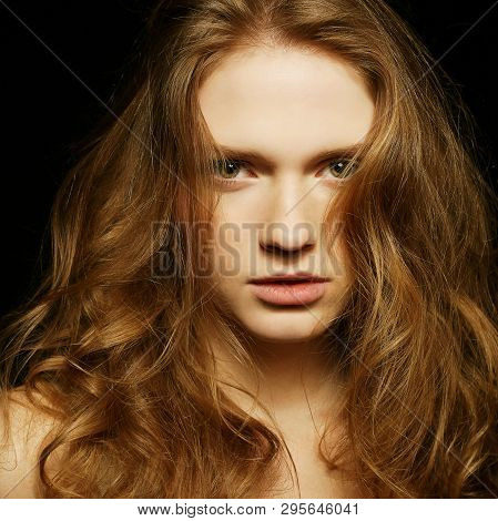 Emotive Portrait Of Young Beautiful Ginger Girl Over Black Background. Studio Shot