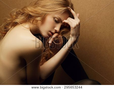 Emotive Portrait Of Young Beautiful Ginger Red Haired Girl On A Wooden Background. Studio Shot