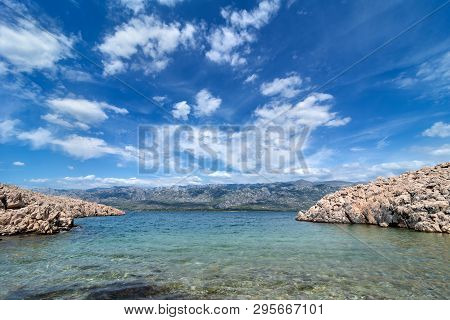 Quiet Bay With Paklenica National Park Mountains In Background. Beautiful Ocean And Dramatic Blue Sk