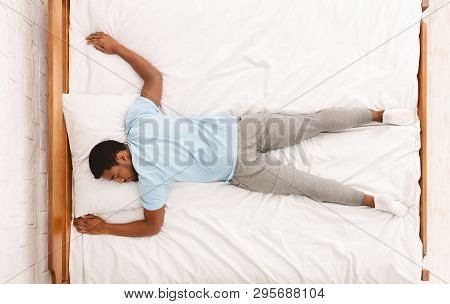 Favorite Pose For Sleep. African American Millennial Guy Sleeping, Lying On Stomach In Bed, Top View