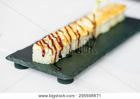 Putting Sauce On Uncut Japanese Sushi Roll