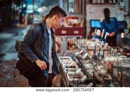 Romantic Asian Couple Looking For Something Special At Seafood Chainese Market. They Are Curious And