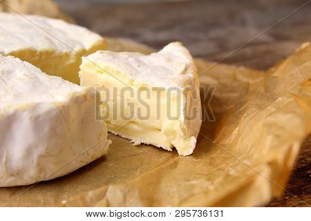 Cow Cheese With White Mold Close-up On A Board.