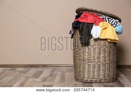 Laundry Basket With Dirty Clothes On Floor Indoors. Space For Text